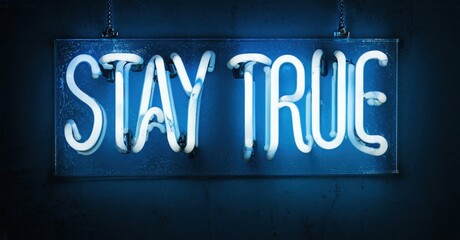 Bright neon sign displays Stay True. Dark background emphasizes glowing text. Simple message, bold presentation.