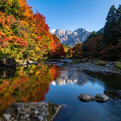 Vibrant autumn foliage frames a mountain river, reflecting peaks