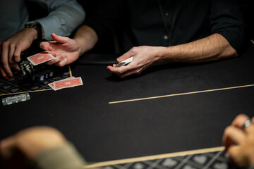 Casino poker dealer dealing playing cards to players at professional gaming table, showing regulated card distribution process within live gambling operations