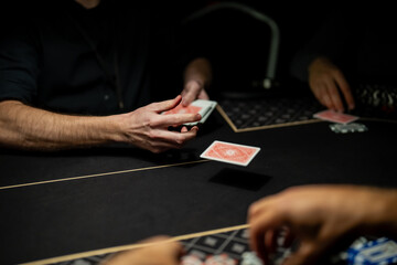 Casino poker gameplay moment with dealer actively dealing cards across table while players prepare bets, highlighting professional gambling operations