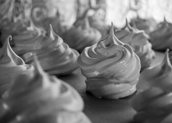 Beautifully shiny sweet meringues made from egg whites arranged on a baking tray, traditional...