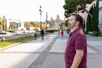 Latin American man admiring city architecture while exploring Barcelona, Catalonia with a sunny sky