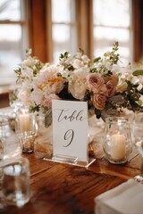 Elegant wedding place card with floral arrangement as centerpiece on a polished wooden table
