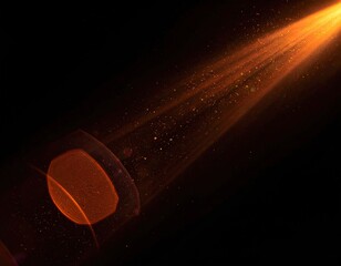 Orange beam of light flares with particles against a dark background