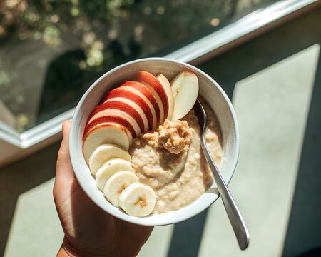 Healthy breakfast oatmeal bowl with apple and banana slices