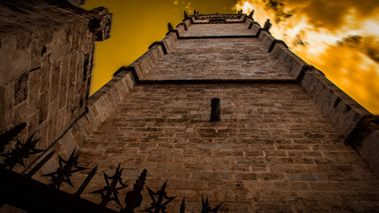 Torre campanario con gárgolas, nubes marrones de forma siniestra, catedral de Valencia © Ramón Reyes
