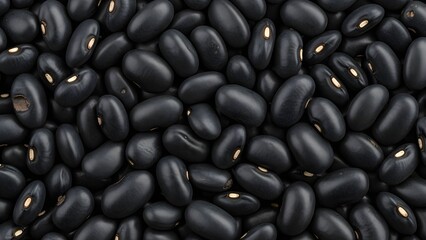 A close-up view of a large pile of black beans with visible white spots