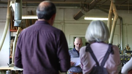 Senior carpentry instructor teaching a woodworking class to students