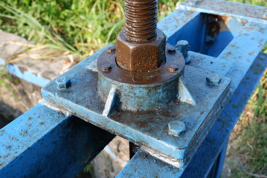 Industrial Blue Hydraulic Jack Screw On Rusty Metal Frame In Outdoor Setting