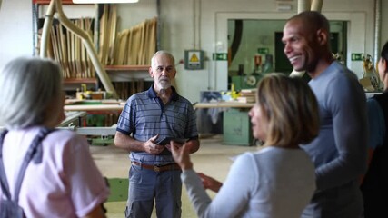 Senior carpenter leading a woodworking class in workshop