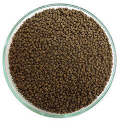 Close-up of fish food pellets in a glass bowl on white background