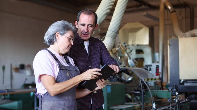 Two senior workers supervising production in a carpentry workshop