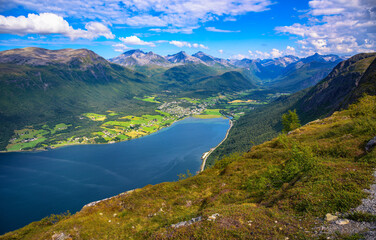 Stunning view from Nesaksla mountain overlooking the village of Isfjorden and the fjord Romsdalsfjorden, surrounded by the majestic Romsdal mountains in western Norway.