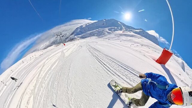 POV action shot of a young man snowboarding downhill while filming with a 360 camera. Sunny winter day, fresh snow, fast movement and outdoor adventure lifestyle in the mountains. Perfect for sports, 