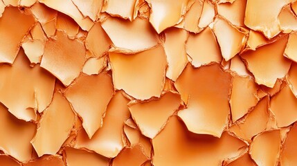 Jagged fragments of ceramic glazes chipped and fractured forming an abstract textured pattern in earthy orange tones