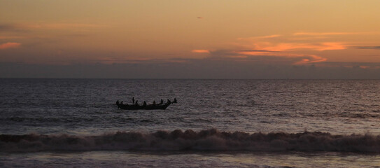 Traditional wooden fishing boat at sunset, scene near Galle, Sri Lanka.