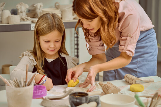 Mother And Daughter Pottery Class: Hands-On Clay Lesson In A Bright Studio - Powered by Adobe