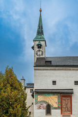 Historic chapel tower with sundial and mural in Salzburg Fortress
