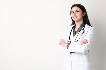 Fototapeta premium Doctor in medical uniform with stethoscope on white background, space for text