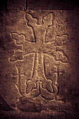 Khachkar - medieval Armenian headstone bearing carved cross, life scenes or decorative interlaces and botanical motifs. Close up sepia toned image