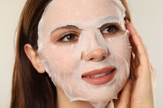 Woman with facial mask on light grey background, closeup - Powered by Adobe