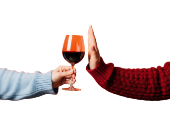 macro shot of two arms, one in light blue cashmere offering red wine, the other in deep crimson cable knit refusing it, orange bokeh background concept of modern resolve