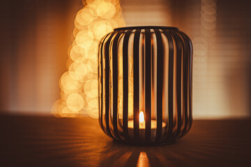 Christmas candle and Christmas lights. In background Christmas tree.