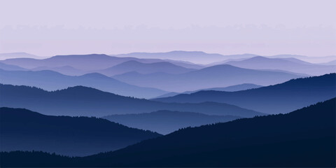 Fototapeta premium A misty blue mountain range at dawn with a forest valley under a soft morning sky where sunlight breaks through the fog and clouds over the peaks.