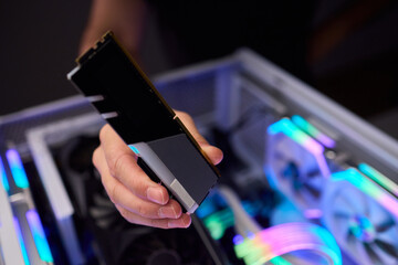 Upgrading computer with RGB lighting, Close up of hardware components during upgrade, Detailed view of installing RAM module into gaming computer with stylish lighting