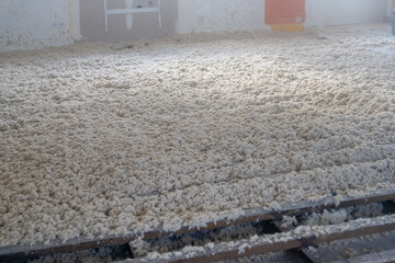 Texture naturelle de laine de bois d'isolation soufflée à la machine, douce et fibreuse, évoquant authenticité, artisanat et matières textiles naturelles pour rénovation énergétique du plancher maison © Thomas
