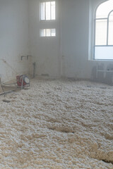 Texture naturelle de laine de bois d'isolation soufflée à la machine, douce et fibreuse, évoquant authenticité, artisanat et matières textiles naturelles pour rénovation énergétique du plancher maison © Thomas