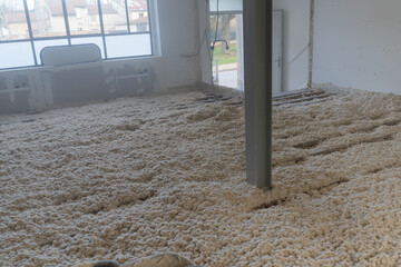 Texture naturelle de laine de bois d'isolation soufflée à la machine, douce et fibreuse, évoquant authenticité, artisanat et matières textiles naturelles pour rénovation énergétique du plancher maison © Thomas