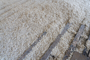 Texture naturelle de laine de bois d'isolation soufflée à la machine, douce et fibreuse, évoquant authenticité, artisanat et matières textiles naturelles pour rénovation énergétique du plancher maison © Thomas