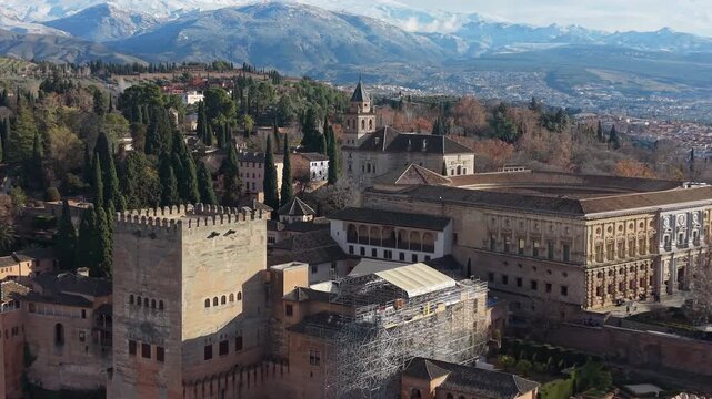 Expansive aerial view of the historic Alhambra palace complex with the Sierra Nevada in the background