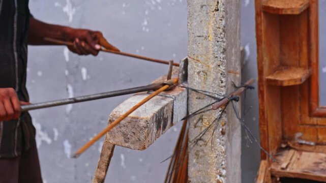 Close up of worker Bending 8MM TMT Rebar for column rings at construction area. day time, stable shot, 4k.