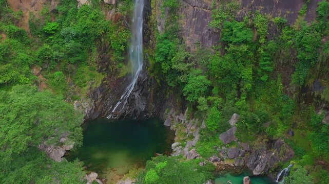 Drone pull-away identifies the towering Cato&aacute; Waterfall near Campo Alegre, Tocantins, highlighting its 70-meter emerald cascade and the ancient quartzite canyon walls of the Serras Gerais region.