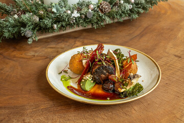 Gourmet venison dish with vegetables and festive garnish on rustic table
