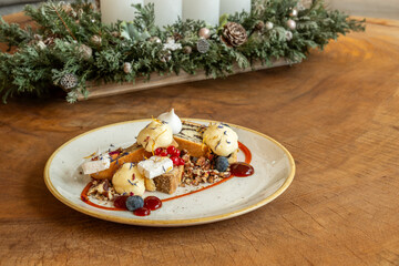 Elegant holiday dessert with cake, berries, and cream on rustic table
