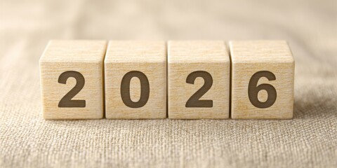 Ultra realistic close up of pale wooden cubes displaying the year 2026 on textured background
