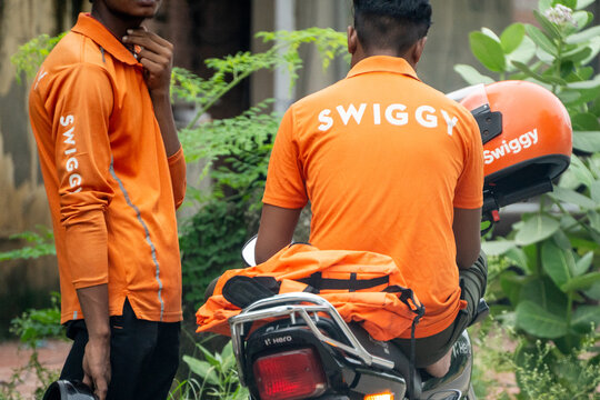 Food delivery rider from Swiggy with a zomato bag showing the multi hatting with food technology apps that the gig workers do to ensure sustainable income