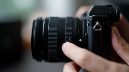 Camera lens focus ring closeup with hand adjusting aperture and tactile grip shallow depth of field soft background concentrated professional mood close up camera lens mirrorless camera body subtle