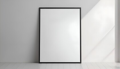 Minimalist interior mockup with a blank vertical black frame leaning against a white wall with soft sunlight shadows.