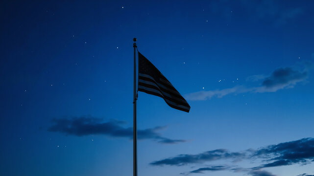 Serene american flag waving gently against a dark blue twilight sky with faint stars and clouds - Powered by Adobe