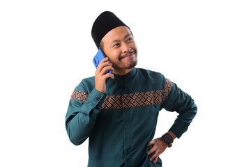 Confident Asian Muslim man attentively listening during a phone conversation. Isolated on a white background. Concept of professionalism, client communication, remote work, or business interaction