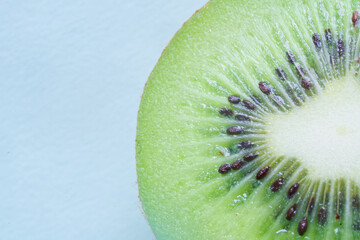 Cross-section of ripe kiwi showing vibrant green flesh and white core. Healthy vegetarian diet concept with text space on the left. Photo