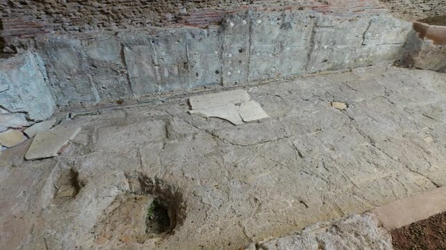 eye level lower section baths caracalla curved shallow pool base weathered cement floor drainage holes remnants pink plaster walls view of rome italy emperor eye-level 