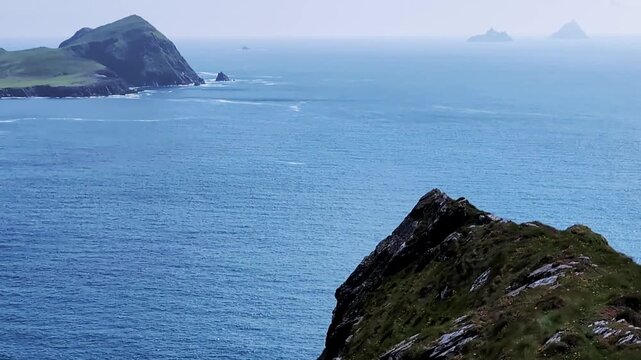 Kerry Cliffs, blue Atlantic Ocean and Skellig Islands on horyzon on a sunny summer day, Portmagee, Ring of Kerry, Ireland.	
