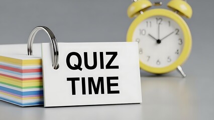 Quiz time concept with a stack of colorful flashcards and a yellow alarm clock