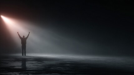 Beacon of Hope: A solitary figure, silhouetted against a dramatic backdrop, stands with arms raised, bathed in a single beam of light, symbolizing hope and aspiration.