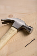 Claw Hammer with Nail on Wooden Plank